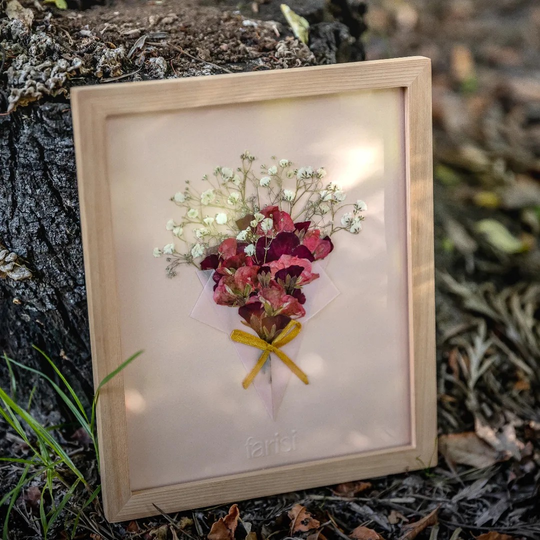 Cuadro con flores prensadas cardenales rosados e ilusión de novia